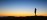 Person lying on grass watching clouds at dawn - gentle sunrise sky for rest and renewal