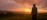 Woman walking barefoot on dewy grass at sunrise - grounding morning landscape for holistic health